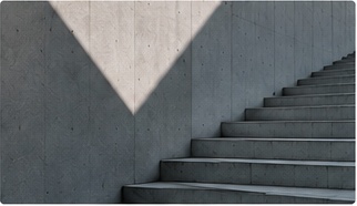 Concrete staircase against a wall with a wedge of daylight
